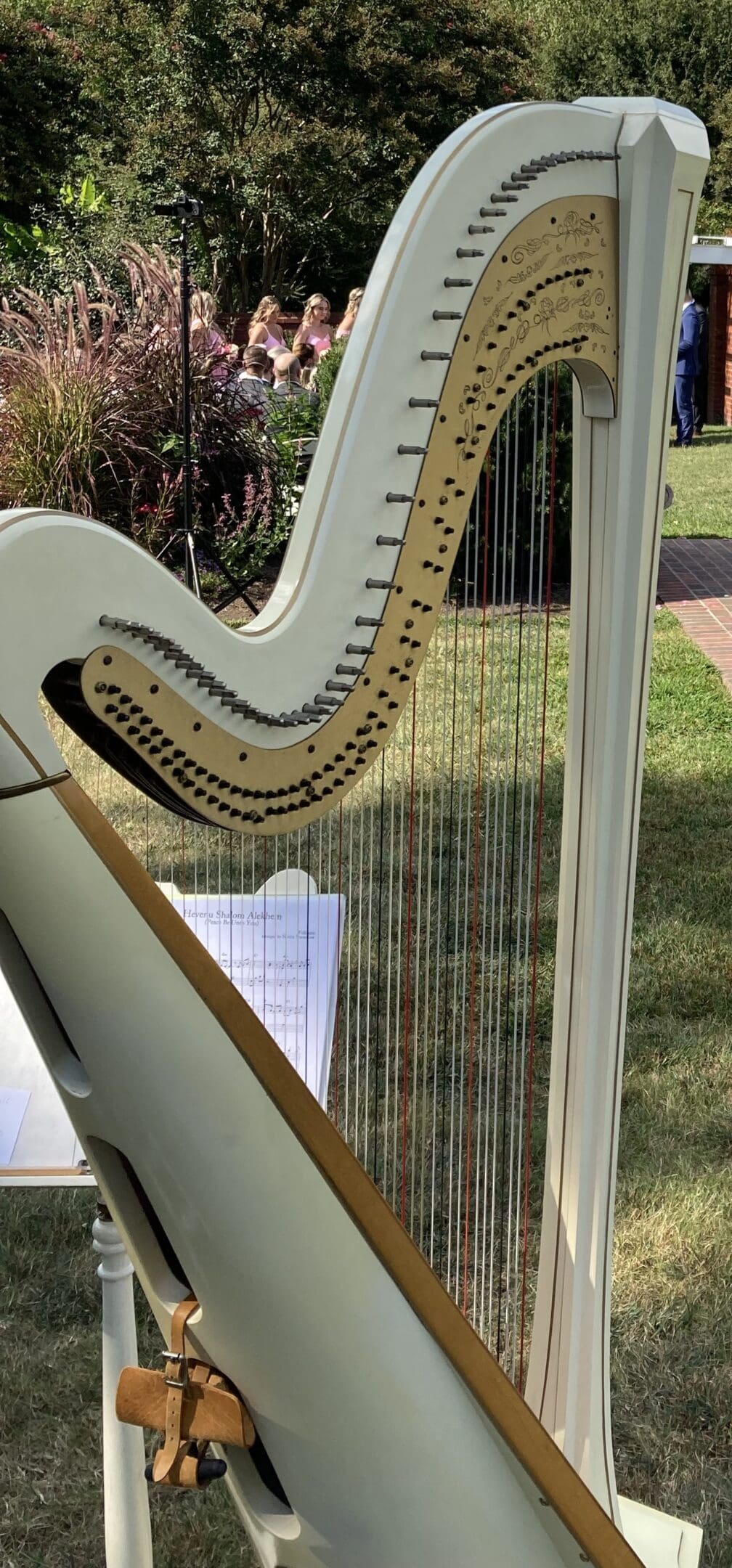 Close-up of a harp with sheet music outdoors on a sunny day.